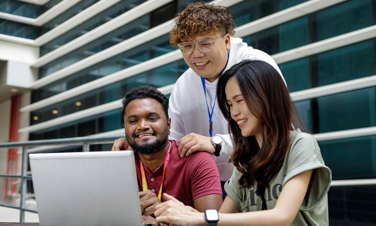 A group of people collaborating on a laptop in an outdoor setting